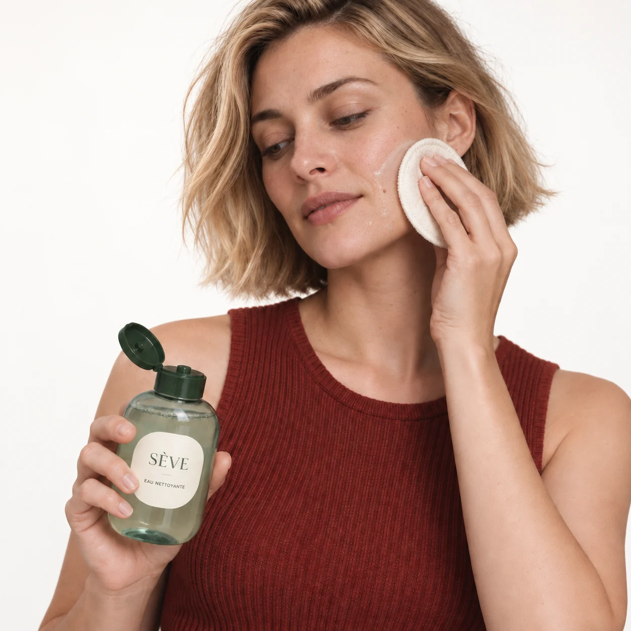 Femme utilisant un coton avec une eau nettoyante
