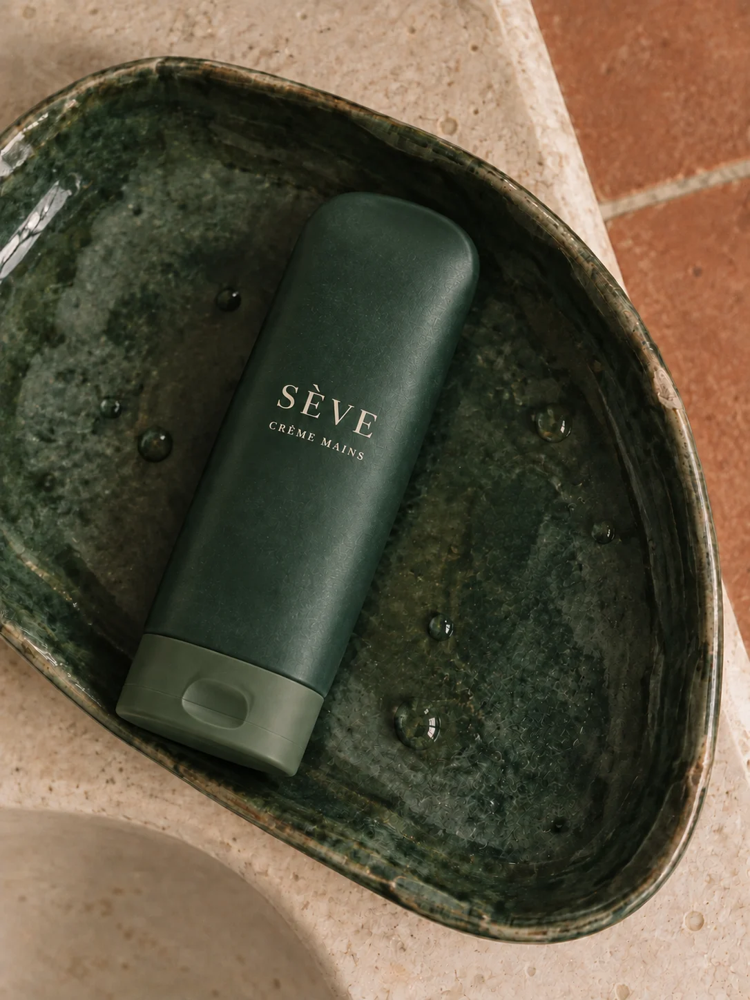 Crème pour les mains verte dans une coupelle en céramique