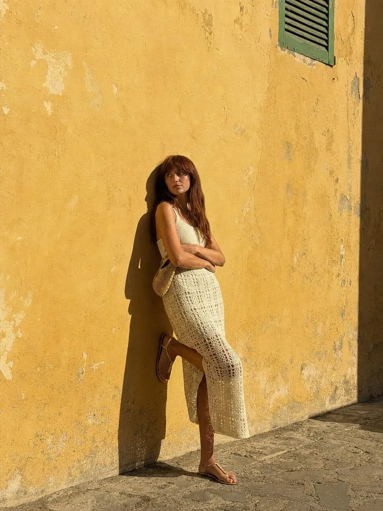 Jupe longue en crochet devant un mur ocre